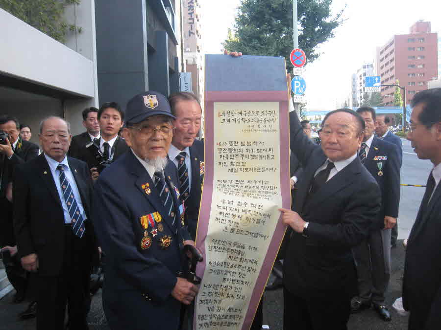 Hyun Kyung-dae, Executive Vice Chairperson, delivering a commemorative poem to Lee Bong-nam, Chairman of the volunteer Korean students soldiers in Japan among Korean War Veterans